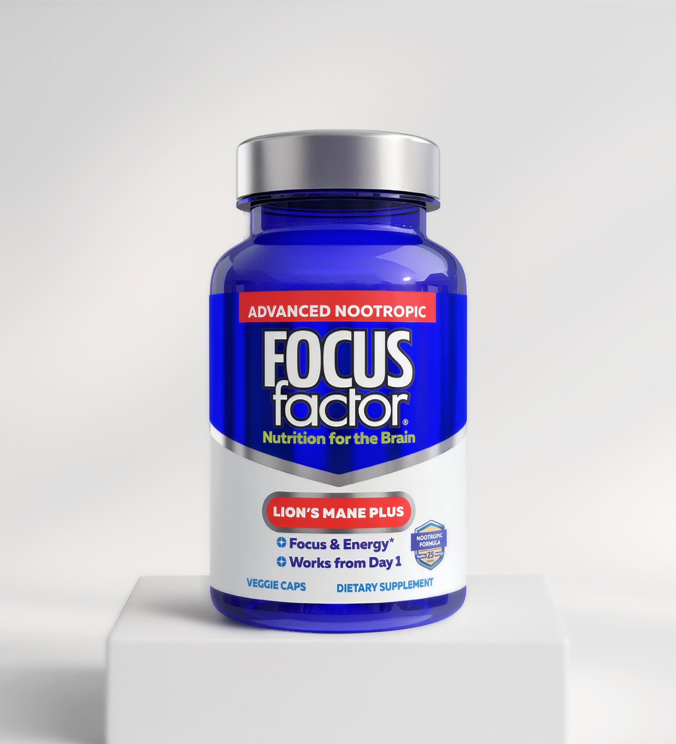 A blue bottle of Focus Factor® Lion's Mane Plus - Focus & Energy* is shown on a white pedestal with a light background. The label emphasizes "Focus & Energy*" and "Works from Day 1.